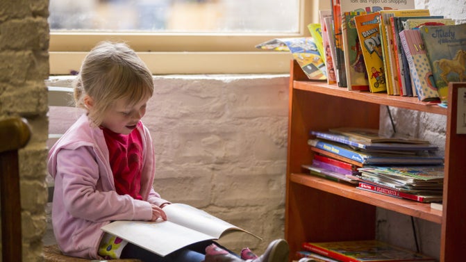 Child reading in the bookshop at Gibside, Tyne & Wear